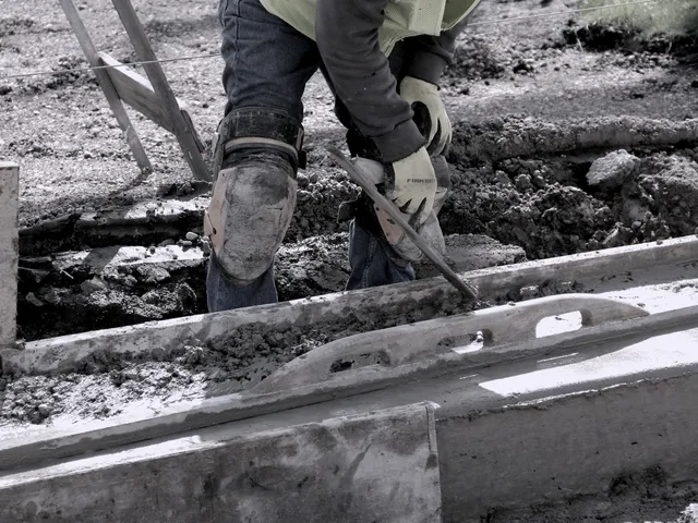 Setzen von Randsteinen in ein frisches Betonbett
